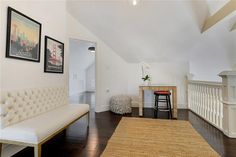 a living room filled with furniture and a white couch next to a wooden table on top of a hard wood floor