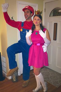 a man and woman dressed up as mario and luigi in front of a door,