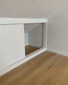 an empty room with white walls and wooden floors