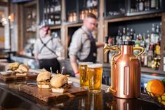 two men behind the bar preparing food and drinks