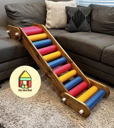 a wooden toy slide sitting on top of a carpeted floor next to a couch