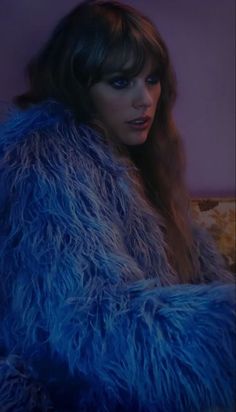 a woman with long hair wearing a blue fur coat