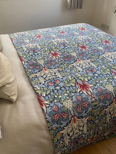 a bed with a blue and red bedspread on top of it