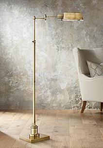 a gold floor lamp with a white chair in the background