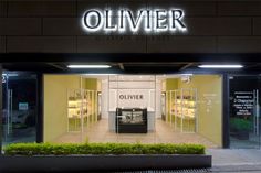 an illuminated store front with the word olivver on it's side and lit up at night