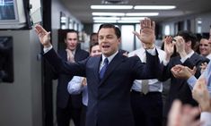 a group of men in suits and ties standing around each other with their hands up