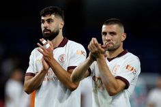 two soccer players applauding each other with their hands together