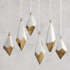 five white and gold ornaments hanging from strings