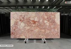 a large slab of marble is on display in a room with metal racks and overhead lighting