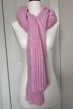 a pink knitted scarf sitting on top of a mannequin