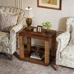 a living room with two chairs and a table in front of the chair is a lamp