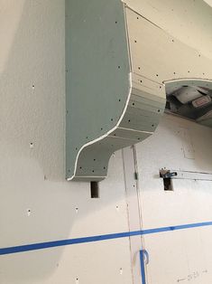 the inside of a building that is being painted white and has blue tape on it