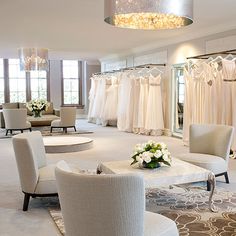 a room filled with lots of white furniture and dresses hanging on the racks in front of them