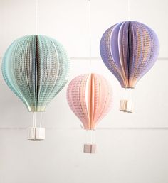 three paper hot air balloons hanging from strings in the shape of fish scales and lines