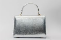 Width: 9" Height: 7" Width: 4.5" Full length of the strap : 41" Timeless Elegance: Ege Silver Leather Handbag" Sleek Silver Leather: Exuding timeless elegance, this handbag is meticulously crafted from premium silver leather for a sleek and sophisticated appearance. Elegant Silver Accents: Enhance your style with tasteful silver accents, adding a touch of refinement to the overall design. Single-Compartment Simplicity: Embrace modern and minimalist appeal with a sleek one-compartment design. Ver Elegant Party Flap Bag With Removable Pouch, Elegant Party Flap Bag With Detachable Strap, Chic Silver Top Handle Box Bag, Chic Silver Box Bag With Top Handle, Evening Shoulder Bag With Silver-tone Hardware And Top Handle, Silver Rectangular Box Bag With Top Carry Handle, Elegant Satchel Flap Bag For Party, Elegant Party Satchel Flap Bag, Elegant Party Flap Satchel Bag