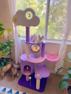 a cat sitting on top of a purple tower in front of a window with stars and moon decorations