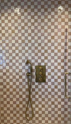 a tiled bathroom with a shower head and hand held shower faucet in it