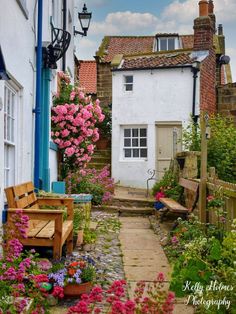 an alley way with flowers and benches in the middle