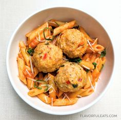 pasta with meatballs and cheese in a white bowl on a beige tablecloth background