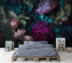 a bed sitting in front of a wall with flowers on it