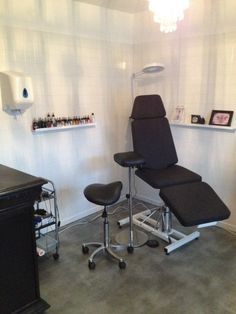 a chair and foot stool in a room with white tiles on the wall behind it