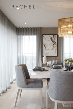 a dining room table with chairs and a chandelier hanging from the ceiling