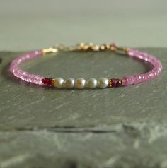 This pink sapphire and pearl bracelet has gorgeous Japanese Akoya pearls framed by rare rich rose sapphires and 18K solid gold beads, leading to sweet pink sapphires.  This feminine women's jewelry bracelet, closes with a 14K solid gold clasp, and has an additional pink sapphire at the closure. The sapphires in this bracelet are a lovely pink and rich rose colors, sparkling and translucent.  The pink sapphires are perhaps a touch softer toned than the photos show.  The Akoya baroque pearls are h Elegant Rondelle Pearl Bracelet With Gemstone Beads, Pink Rondelle Elegant Jewelry, Elegant Pink Rondelle Jewelry, Elegant Pink Pearl Bracelet As A Gift, Elegant Pink Pearl Bracelet Gift, Elegant Pink Pearl Bracelet For Gifts, Rose Colors, Pink Beaded Bracelets, Blue Sapphire Bracelet