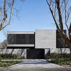 the house is made out of concrete and has black shutters