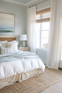 a bedroom with a large bed and white curtains