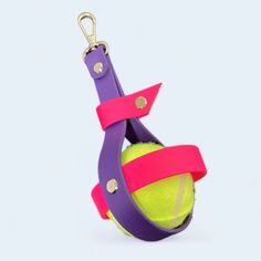 a purple and pink tennis ball on a keychain that is attached to a hook