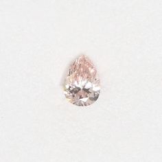 a pink diamond on a white surface with no other diamonds in the photo to be seen