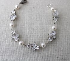 This is the perfect accessory for your wedding and special occasion event. This bracelet has timeless pearls and sparkly cubic zirconia stones.  Crystal bracelet is made with Austrian pearls in white and leafy cubic zirconia marquise. Bracelet measures approximately 6 1/2" long with 1 1/2" extender chain (8" total).  Each link measures approximately 5/8" by 3/8" wide.  Hand linked pearls measure 6mm.  I can also use 4 or  5mm pearls if you like please ask! *If you need a longer length please mes Marquise Bracelet, Elegant Pearl White Crystal Wedding Bracelet, White Heart-shaped Pearl Bracelet For Wedding, Heart-shaped Pearl Bracelet With Charm For Wedding, White Pearl-embellished Bracelet For Party, White Rhinestone Crystal Bracelet, Adjustable, Pearl Bracelet Wedding, Bracelet Wedding, Bracelet Women