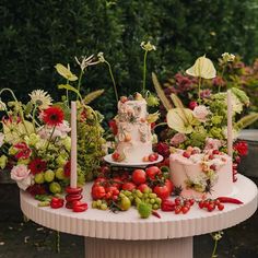 a table topped with lots of different types of cakes and flowers on top of it