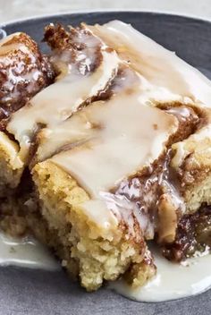 a close up of a plate of food with icing and cinnamon rolls on it