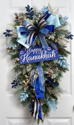 a blue and white christmas wreath with happy hanukkah written on it