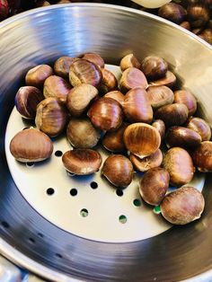 there are many snails in the bowl on the stove top, and one has its shell removed