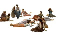 several figurines of people laying on the ground with one holding a woman's head