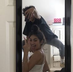 a man and woman taking a selfie in front of a mirror with their reflection