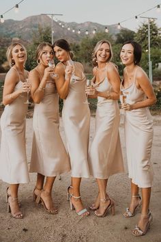 the bridesmaids are all wearing champagne flutes