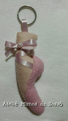 a keychain with a pink ballerina shoe hanging from it's side