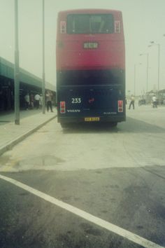 a red and black bus is parked on the street