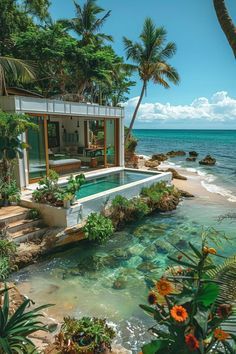 an outdoor swimming pool surrounded by palm trees and the ocean in front of a house