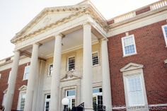 an old brick building with columns on the front