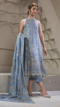 Elegant Blue Short Shirt with Capri Pakistani Party Wear Curated in a wonderful blue tone, blue bell embraces a perfection in its subtle embroidery and sequins work. Paired with a floral design dupatta and a tonal trouser this ensemble is a step towards slaying this season. A stellar piece curated on a navy blue lawn base painstakingly worked in shades of gray & ash white thread is topped with silver spangles & zari creating a floral pattern for the front. Detailed Description: SKU: PB0033 Detai Festive Blue Lawn Suit For Party, Elegant Summer Designer Unstitched Suit, Blue Lawn Suit With Zari Work For Party, Party Blue Lawn Suit With Zari Work, Formal Blue Lawn Suit With Dabka Work, Elegant Blue Unstitched Suit With Dabka Work, Elegant Blue Lawn Suit For Diwali, Traditional Blue Unstitched Suit For Summer, Blue Bollywood Lawn Suit For Formal Occasions