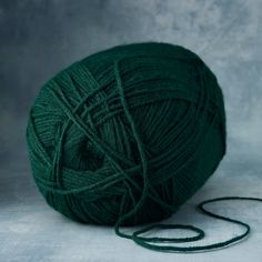 a ball of green yarn sitting on top of a table