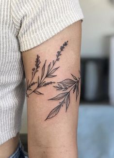 a woman's arm with a black and white flower tattoo on it