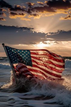 an american flag is floating in the water with waves and clouds behind it as the sun sets