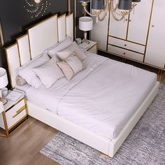 a bed with white sheets and pillows in a bedroom next to a chandelier