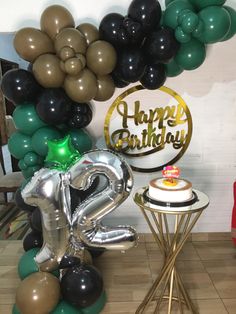 a birthday party with balloons, cake and balloon arch in the shape of an elephant