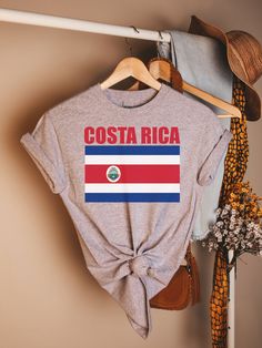 a t - shirt with the flag of costa on it hanging from a clothes rack